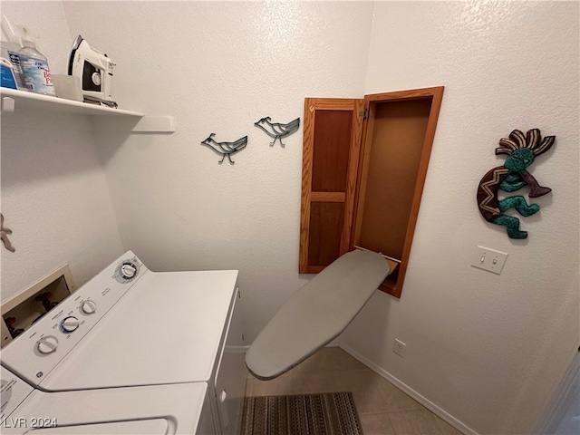 clothes washing area with tile patterned flooring and washer / dryer