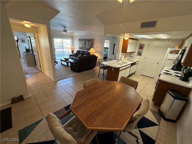 tiled dining area featuring ceiling fan and sink