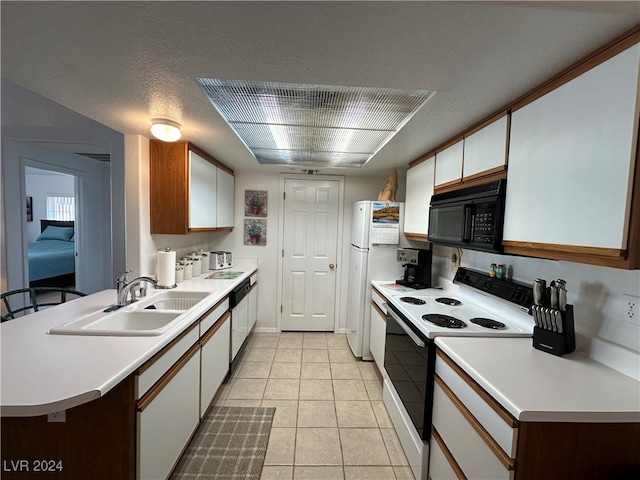 kitchen featuring white cabinetry, sink, a textured ceiling, white appliances, and light tile patterned flooring