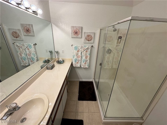 bathroom with vanity, tile patterned floors, and a shower with door