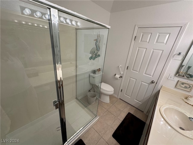 bathroom featuring tile patterned flooring, vanity, toilet, and a shower with shower door