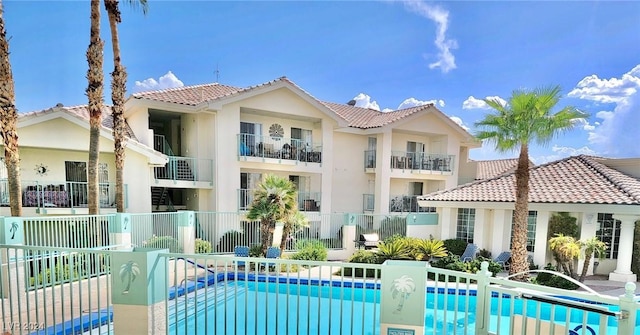 back of house with a fenced in pool