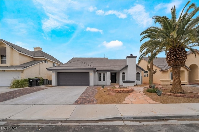 view of front of property with a garage and central AC