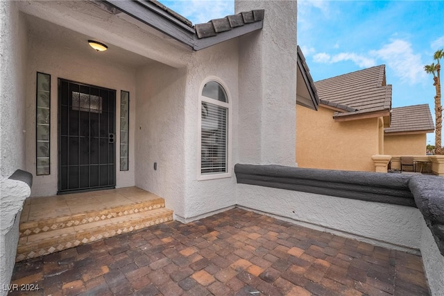 view of exterior entry featuring a patio