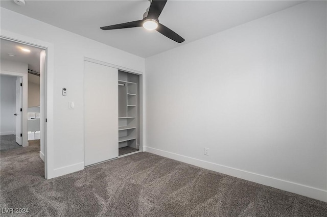 unfurnished bedroom featuring dark carpet, a closet, and ceiling fan