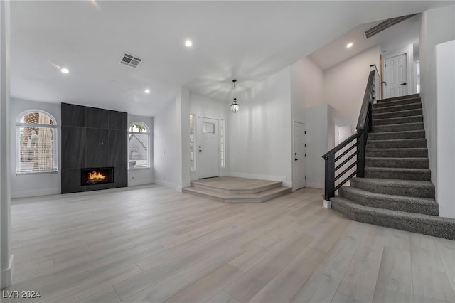 interior space with a tile fireplace and light hardwood / wood-style flooring