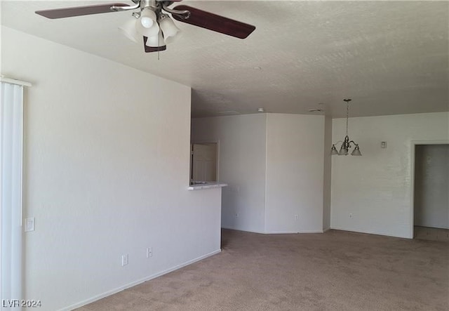 unfurnished room with ceiling fan with notable chandelier and light colored carpet