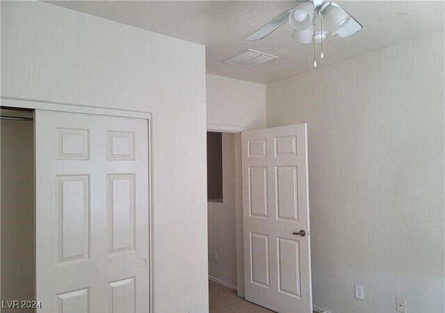 unfurnished bedroom featuring ceiling fan and a closet