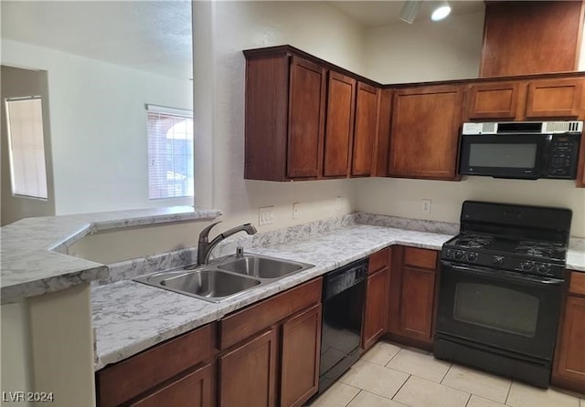 kitchen featuring black appliances, sink, light stone countertops, light tile patterned floors, and kitchen peninsula