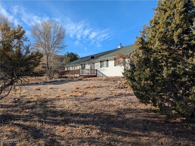 rear view of property featuring a wooden deck