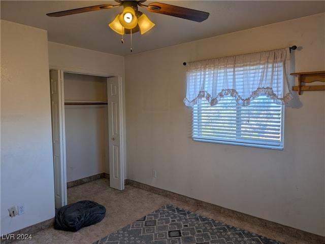 unfurnished bedroom with ceiling fan and a closet