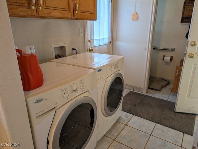 laundry area with washer and dryer, cabinets, and light tile patterned flooring