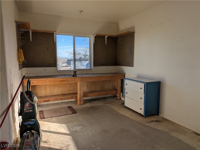 miscellaneous room featuring a workshop area and concrete flooring