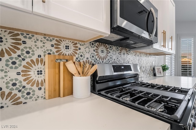 kitchen featuring decorative backsplash, white cabinets, and stainless steel appliances