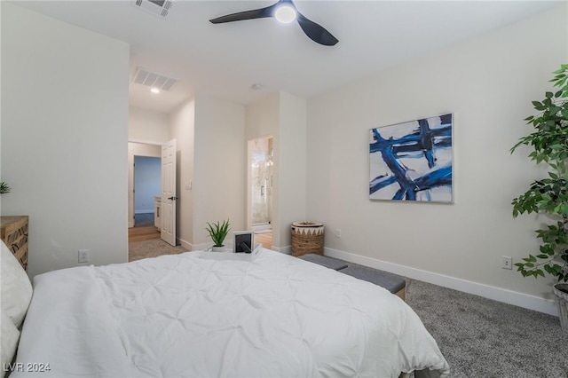 carpeted bedroom with ceiling fan and ensuite bath