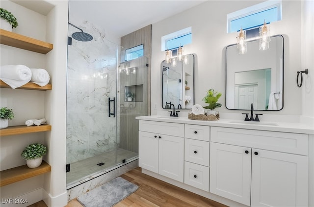 bathroom with hardwood / wood-style floors, vanity, and a shower with shower door