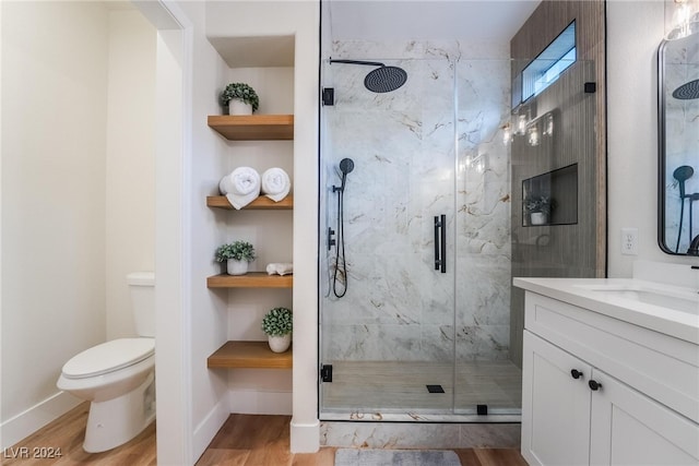 bathroom featuring hardwood / wood-style floors, vanity, toilet, and a shower with shower door