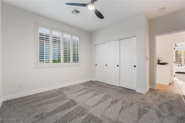 unfurnished bedroom with carpet flooring, a closet, and ceiling fan