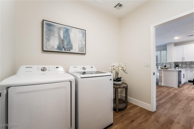 laundry area featuring light hardwood / wood-style floors and washing machine and dryer