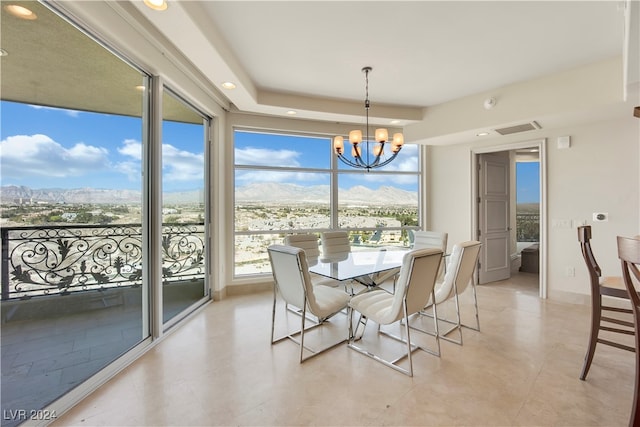 dining area with a mountain view, a healthy amount of sunlight, and an inviting chandelier