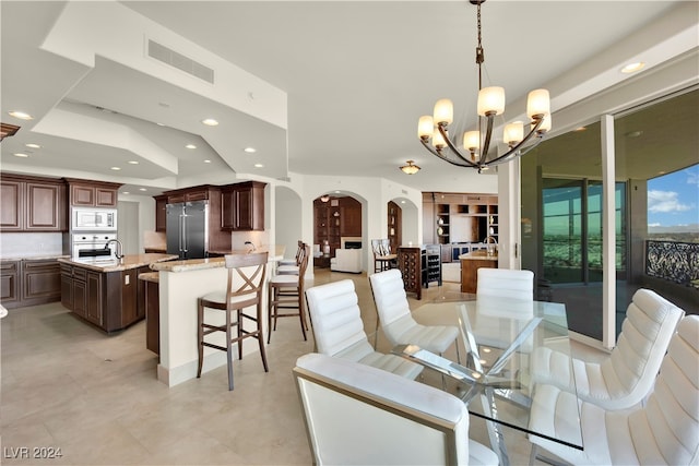 dining space with a chandelier and sink