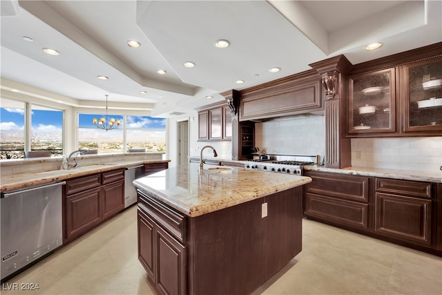 kitchen featuring appliances with stainless steel finishes, an island with sink, hanging light fixtures, and sink