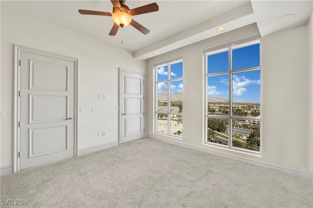 spare room with ceiling fan and light colored carpet