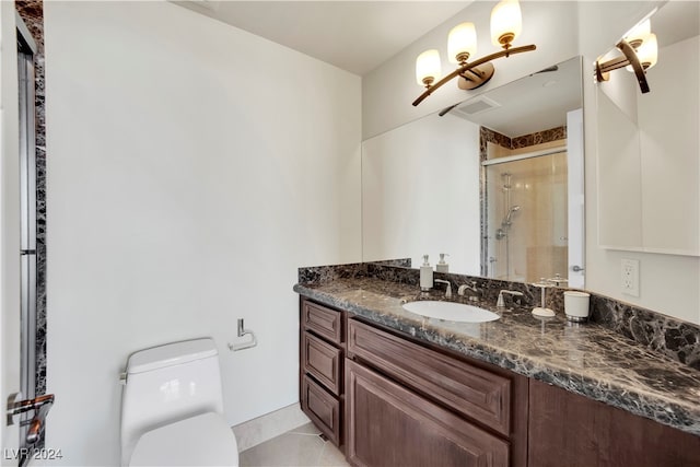 bathroom with tile patterned flooring, vanity, toilet, and a shower with shower door