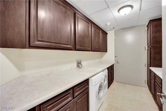 kitchen featuring washer / dryer, a paneled ceiling, and dark brown cabinets