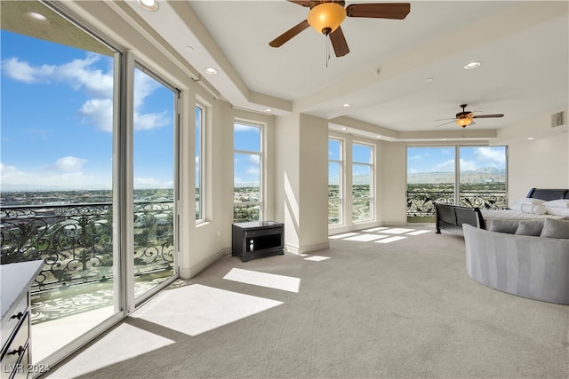 unfurnished living room featuring ceiling fan and light colored carpet