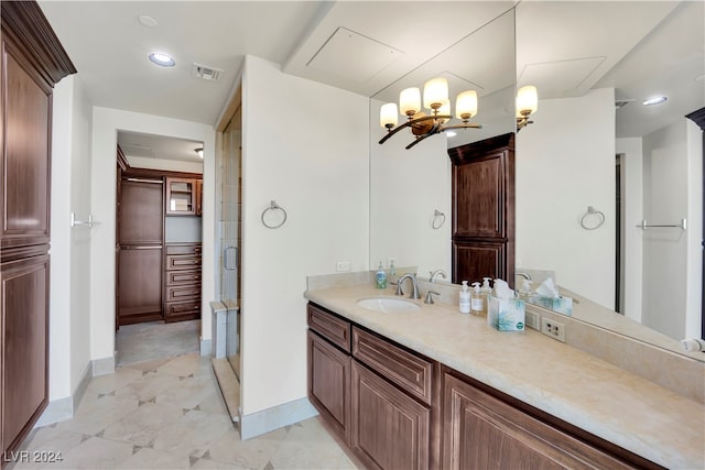 bathroom with vanity, a chandelier, and an enclosed shower