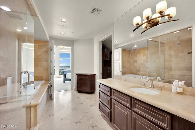 bathroom with a notable chandelier, vanity, separate shower and tub, and tile walls