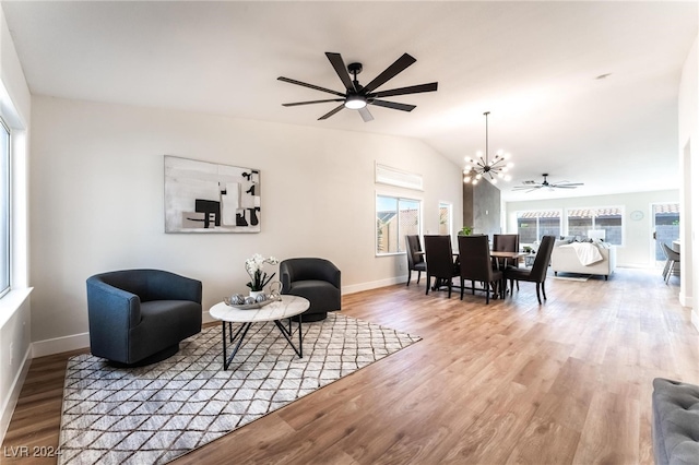 living room featuring ceiling fan with notable chandelier, hardwood / wood-style flooring, and lofted ceiling