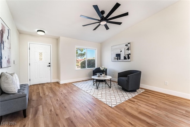 living area featuring hardwood / wood-style floors, vaulted ceiling, and ceiling fan