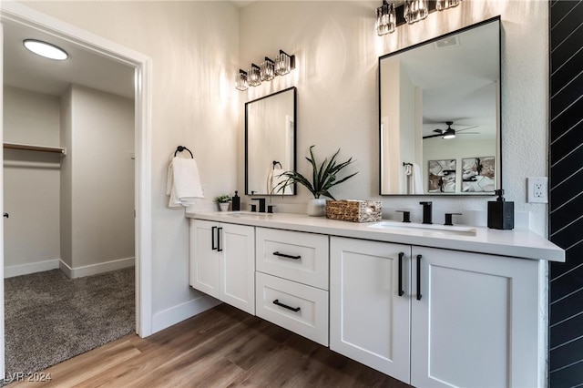 bathroom with wood-type flooring, vanity, and ceiling fan