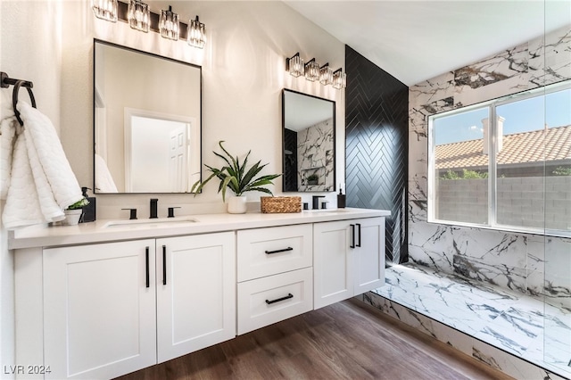 bathroom with hardwood / wood-style flooring, vanity, and tile walls