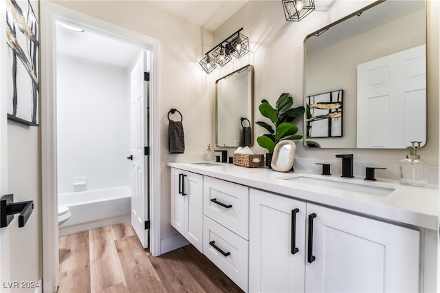 full bathroom with shower / washtub combination, vanity, wood-type flooring, and toilet