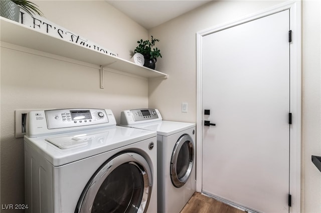 laundry area featuring washer and dryer and dark hardwood / wood-style flooring