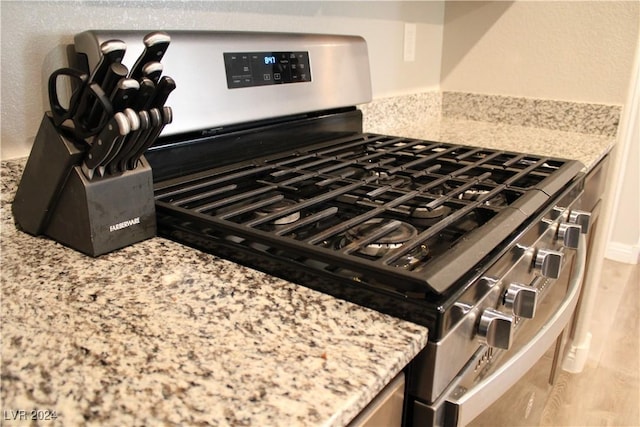 room details featuring stainless steel range with gas cooktop and light stone counters