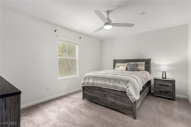 bedroom featuring light carpet, baseboards, and a ceiling fan