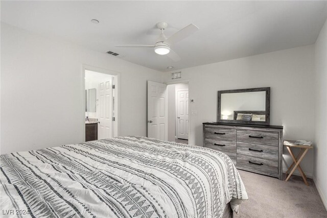 bedroom with visible vents, baseboards, light colored carpet, ensuite bath, and ceiling fan