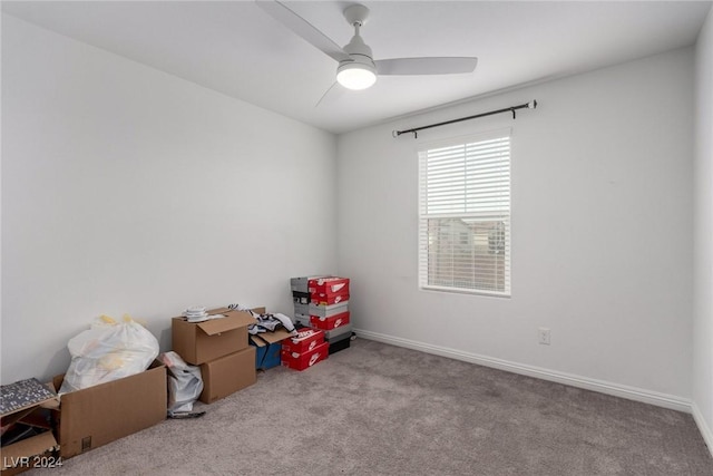 interior space with light carpet, a ceiling fan, and baseboards