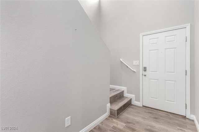 entrance foyer featuring baseboards, stairway, and light wood-style floors