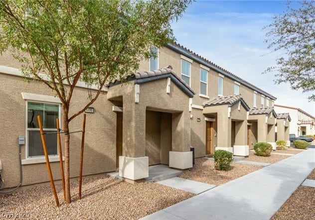 view of front of home featuring a residential view, stucco siding, and a tile roof