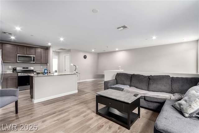 living area featuring recessed lighting, visible vents, and light wood-type flooring