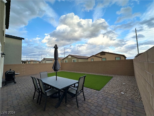 view of patio featuring outdoor dining space, grilling area, and a fenced backyard