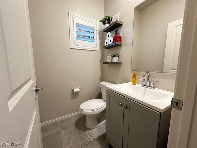 bathroom with toilet, baseboards, and vanity