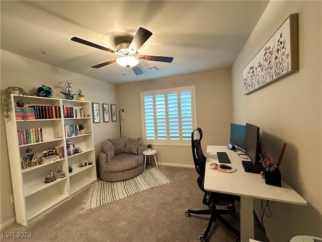 carpeted home office with ceiling fan, visible vents, and baseboards