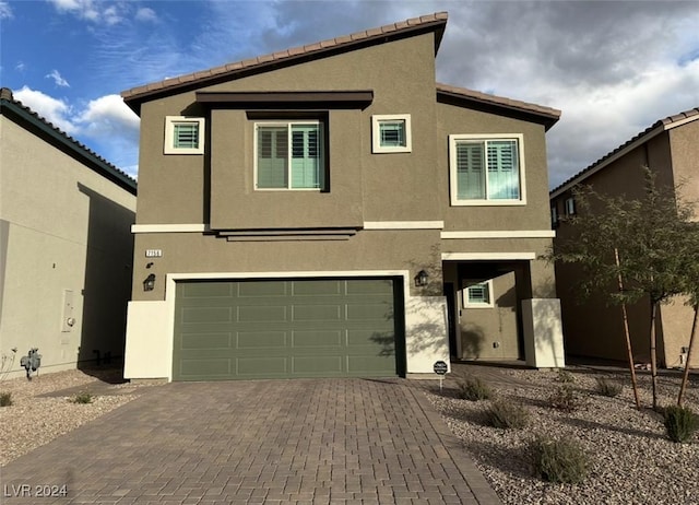 view of front of property with a garage, decorative driveway, and stucco siding