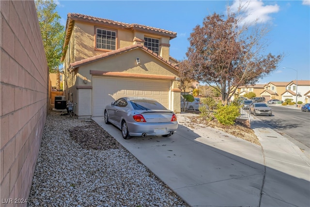 view of front of home with a garage and central air condition unit